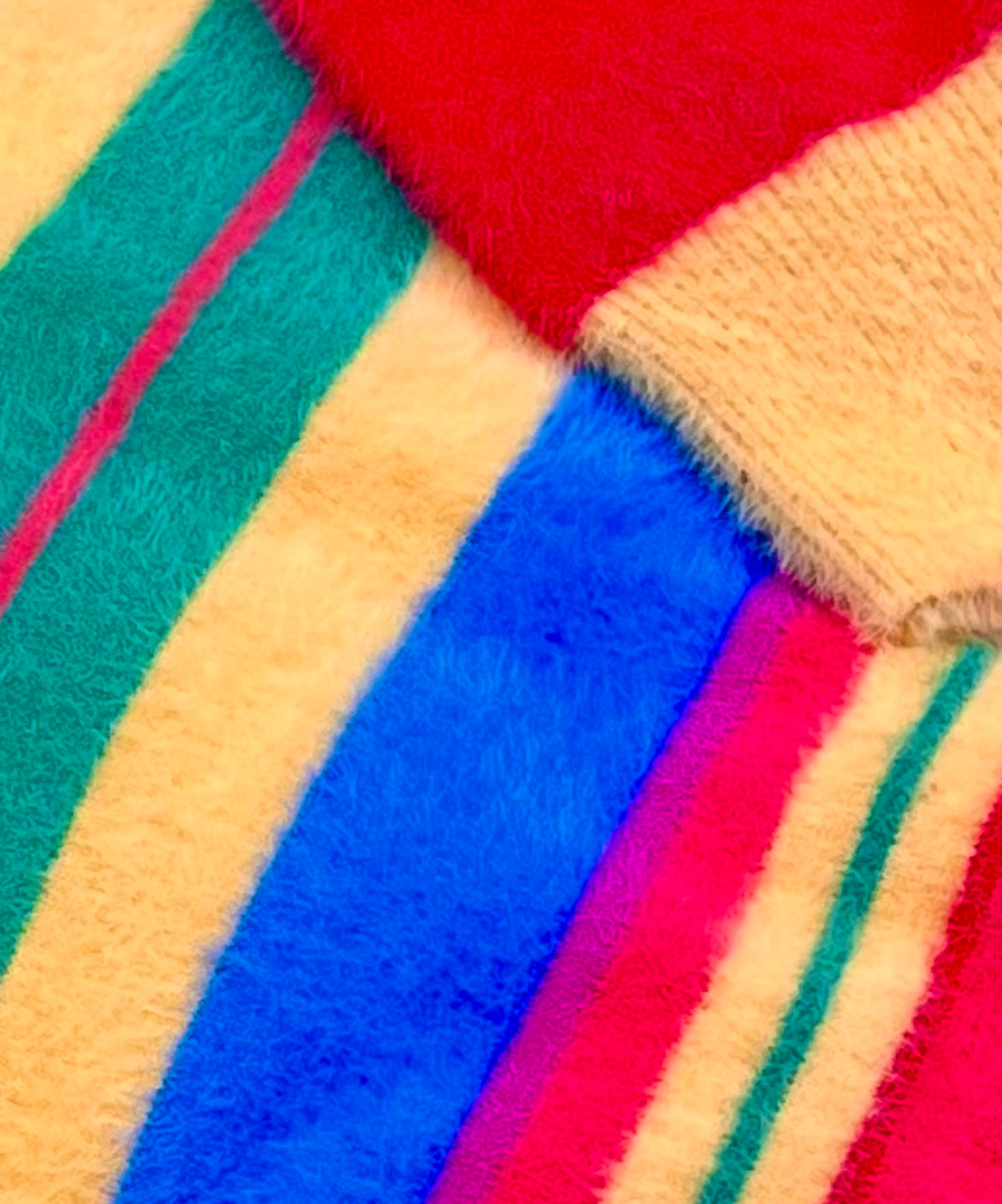 Close-up of colorful fuzzy striped fabric with red, blue, green, yellow, purple and pink.
