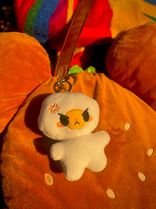 Plush egg keychain with angry expression on a brown burger bag