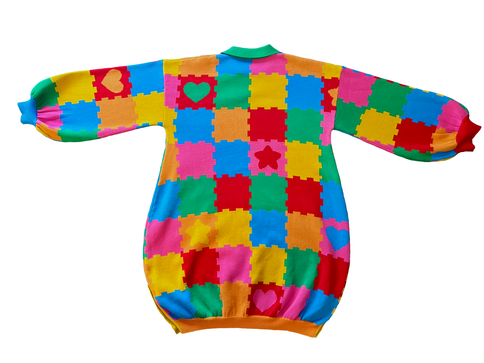 Flat lay of the back of the knit sweater dress with a green collar. The design is bright pink, red, yellow, green, and orange puzzle playmat tiles with some tiles having hearts or stars. 