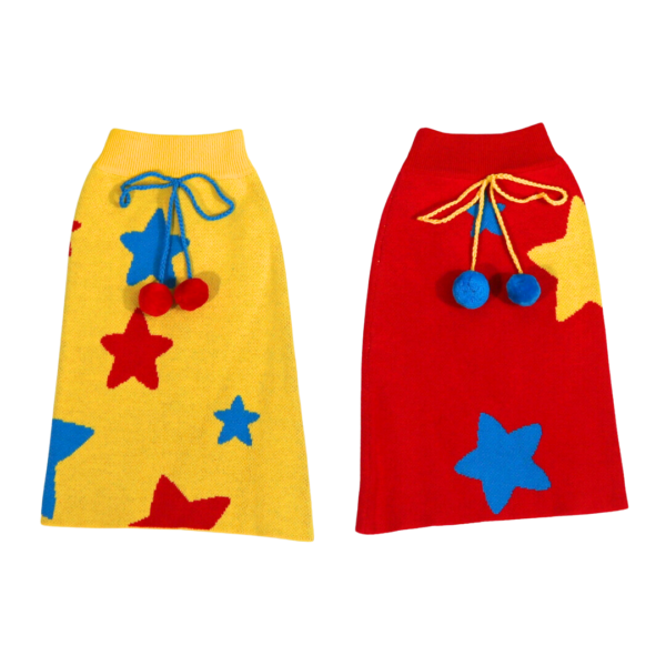 Two legwarmers laid flat on a clear background, one red with blue stars and one yellow with red stars, each with a blue tassel at the end.