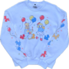 A white crew neck with colorful clown and balloon themed graphics printed on the front and on the sleeves laying flat on a clear background