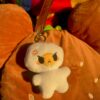 Plush egg keychain with angry expression on a brown burger bag
