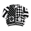 Flat lay of the front of a black and white mismatched pattern cardigan. Sleeves have diagonal stripes. Left panel has diagonal diamond pattern, the right has white stars on a black background with happy face pockets.