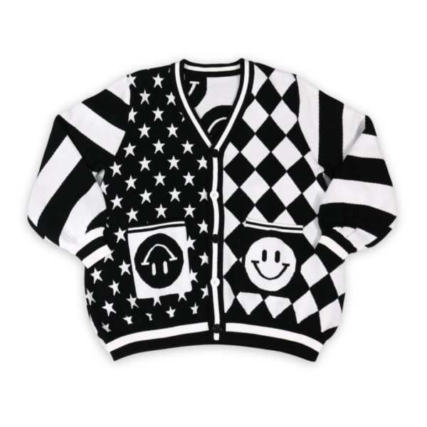 Flat lay of the front of a black and white mismatched pattern cardigan. Sleeves have diagonal stripes. Left panel has diagonal diamond pattern, the right has white stars on a black background with happy face pockets.
