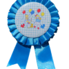 A blue clown rosette pin with a playful clown and balloon graphic in the center.