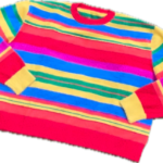 A fuzzy bright rainbow striped sweater laying flat with the sleeves folded on a clear background.