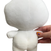 Hand holding a medium sized white plush with its back facing the camera. The white plush features a round head a small body and two round butt cheeks.