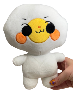 a hand holding medium sized mischievous egg plush. He has a big round white head, two eyes, a yellow yolk in the center of his face and orange round cheeks.