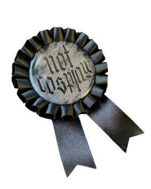 Black rosette pins with the text 'Not Cosplay' in black and white on a clear background