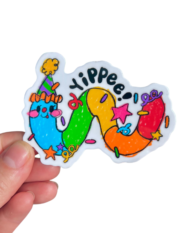 hand holding a multi colored worm wearing a party hat with "Yippee" and confetti on top