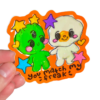 Colorful stickers with an alien cartoon character and egg characters held by a hand on a clear background