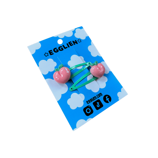 Peach hair clip side A pair of peach cabochons on mint hairclips both on blue backing card that reads "Egglien"