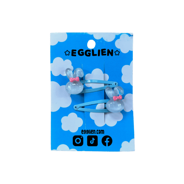 A pair of blue bunny cabochon with a pink bow on blue hairclips both on backing card that reads "Egglien"