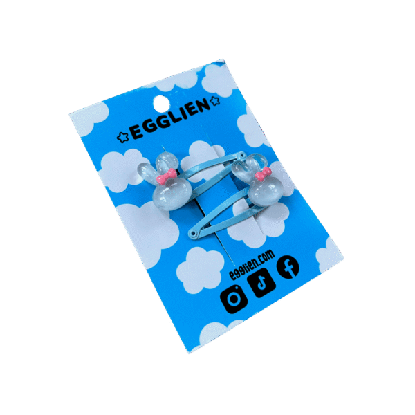 A pair of blue bunny cabochon with a pink bow on blue hairclips both on backing card that reads "Egglien"