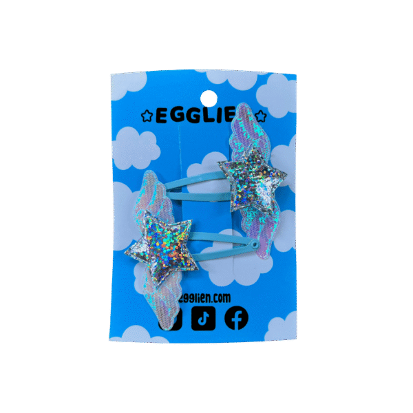 Holo Blue Hair Clip front A pair of holographic stars with wings on blue hairclips both on a blue backing card that reads "Egglien".