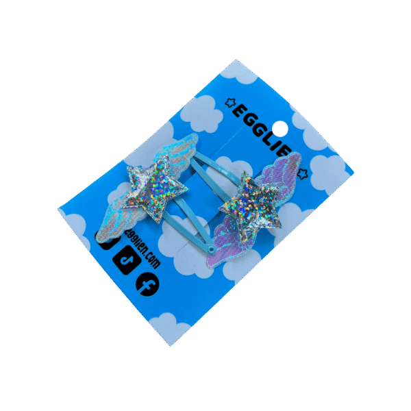 Holo Blue Hair Clip side A pair of holographic stars with wings on blue hairclips both on a blue backing card that reads "Egglien".