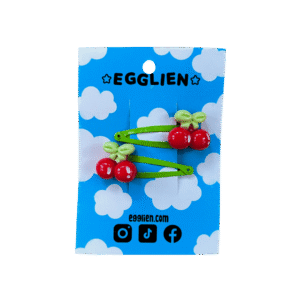 A pair of red cherry cabochons on green hairclips both on backing card that reads "Egglien"