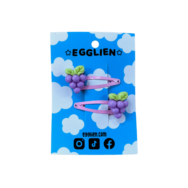 Pink grape hair clip front A pair of grape cabochons on pink hairclips both on blue backing cards that reads "Egglien"