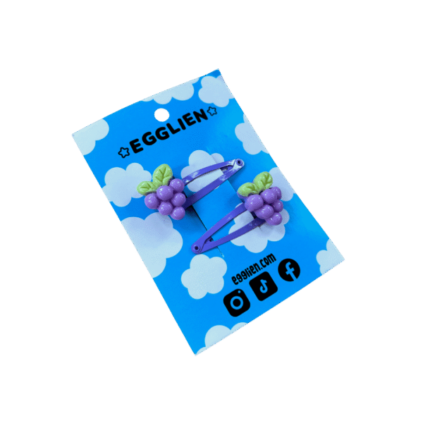 Purple grape hairclip side A pair of grape cabochons on purple hairclips both on blue backing cards that reads "Egglien"