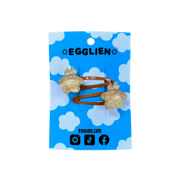 A pair of orange cabochons on orange hairclips both on blue backing card that reads "Egglien"