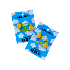 Two pairs of Pineapple hairclips both on a blue backing card that reads "Egglien". One pair has yellow hair clips and one has green hair clips.