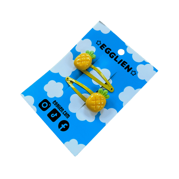A pair of pineapple cabochons on yellow hairclips both on blue backing card that reads "Egglien"