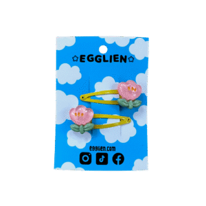 A pair of pink flower cabochons on yellow hairclips both on blue backing card that reads "Egglien"