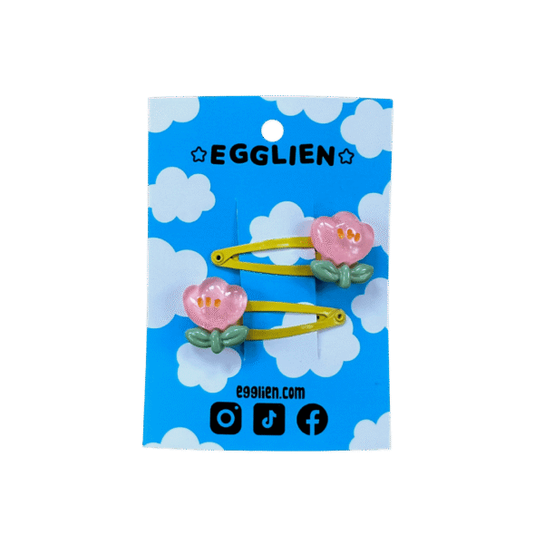 A pair of pink flower cabochons on yellow hairclips both on blue backing card that reads "Egglien"