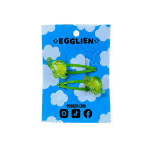 A pair of green turtle resin cabochon on green hairclips both on backing card that reads "Egglien" and "egglien.com"