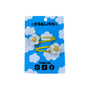 A pair of white and yellow flower resin cabochon on yellow hairclips both on backing card that reads "Egglien"