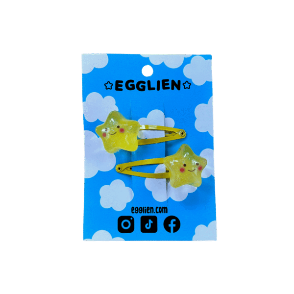 A pair of yellow cheerful star cabochon on yellow hairclips both on backing card that reads "Egglien"