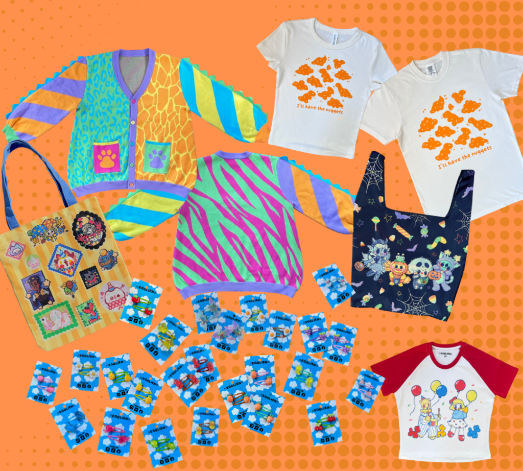 A flat lay of various items on an orange background with dots. Items include a rainbow cardigan, two cream tshirts with orange dinosaur nuggets design, two different bags, a clown crop top and many hairclip sets on a blue background.